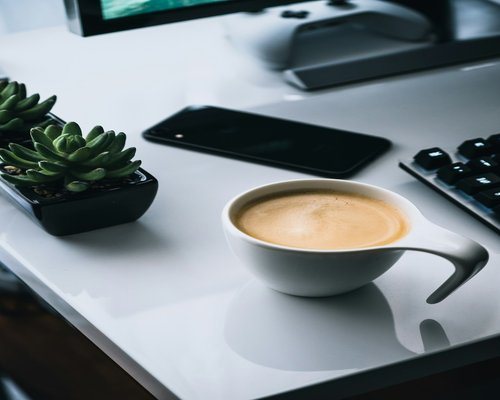 A short break during a regular workday with a coffee cup on the desk